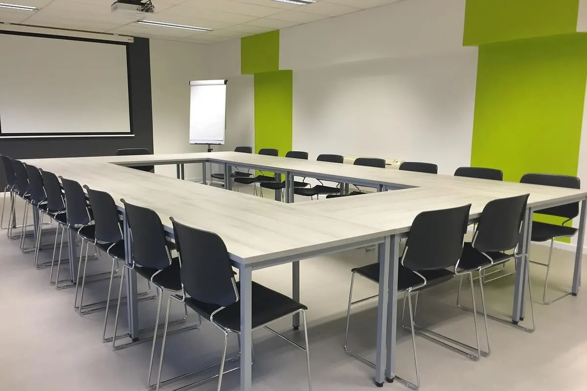 A small group of professionals in an informational meeting, representing the networking conversations that help a career changer break into a new field