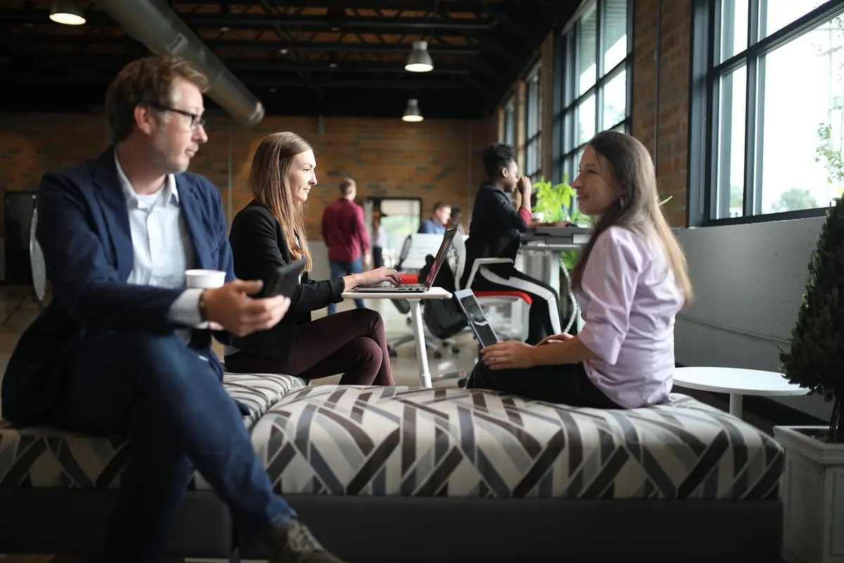 Coworkers collaborating around a table, representing the kind of cross-functional teamwork that builds transferable leadership and communication skills